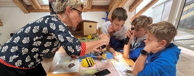 Petra Kohler erklärt einigen Kindern eine Aufgabe im Experimentierlabor