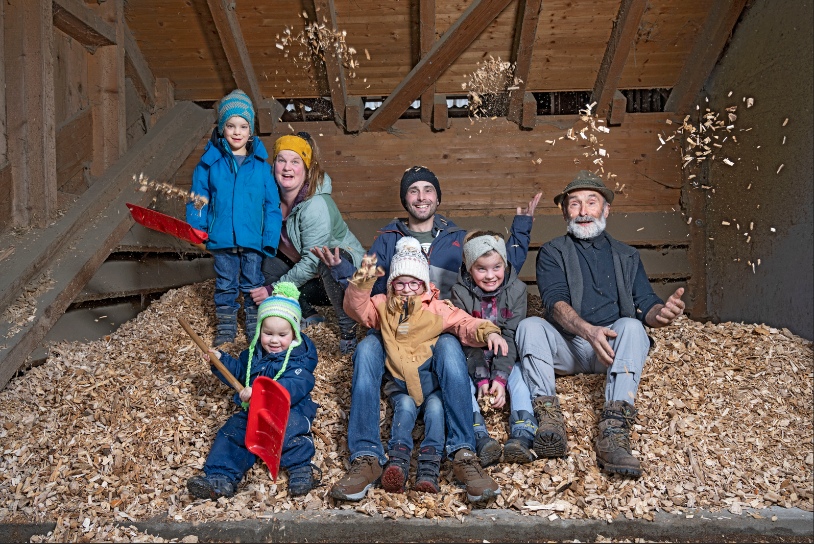 Familie Wagner aus Wattwil sitzt auf einem Haufen aus Holzschnitzel