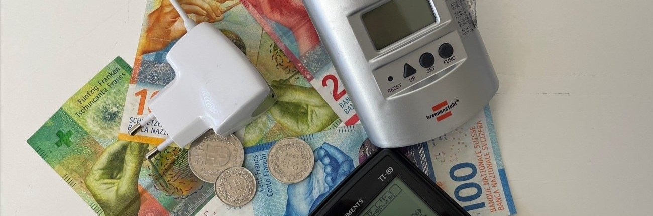 Strommessgerät, Taschenrechner und Bargeld als Symbolbild für Einsparungen beim Stromverbrauch