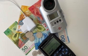 Strommessgerät, Taschenrechner und Bargeld als Symbolbild für Einsparungen beim Stromverbrauch