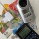Strommessgerät, Taschenrechner und Bargeld als Symbolbild für Einsparungen beim Stromverbrauch