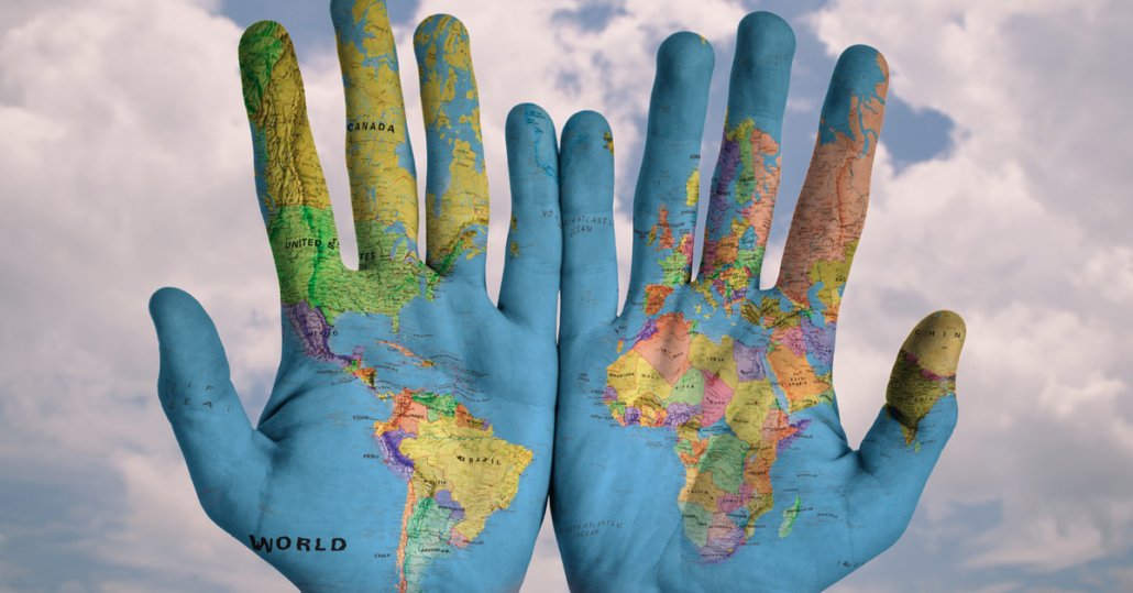 Hände mit dem Muster der Weltkarte