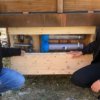 Zwei Arbeiter zeigen die Grauwasseraufbereitungsanlage am Eventhaus
