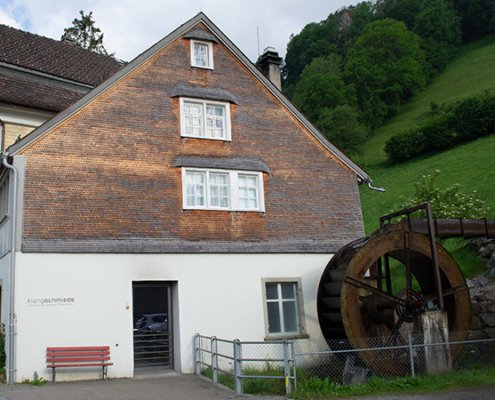 Altes Wasserrad vor Wohnhaus